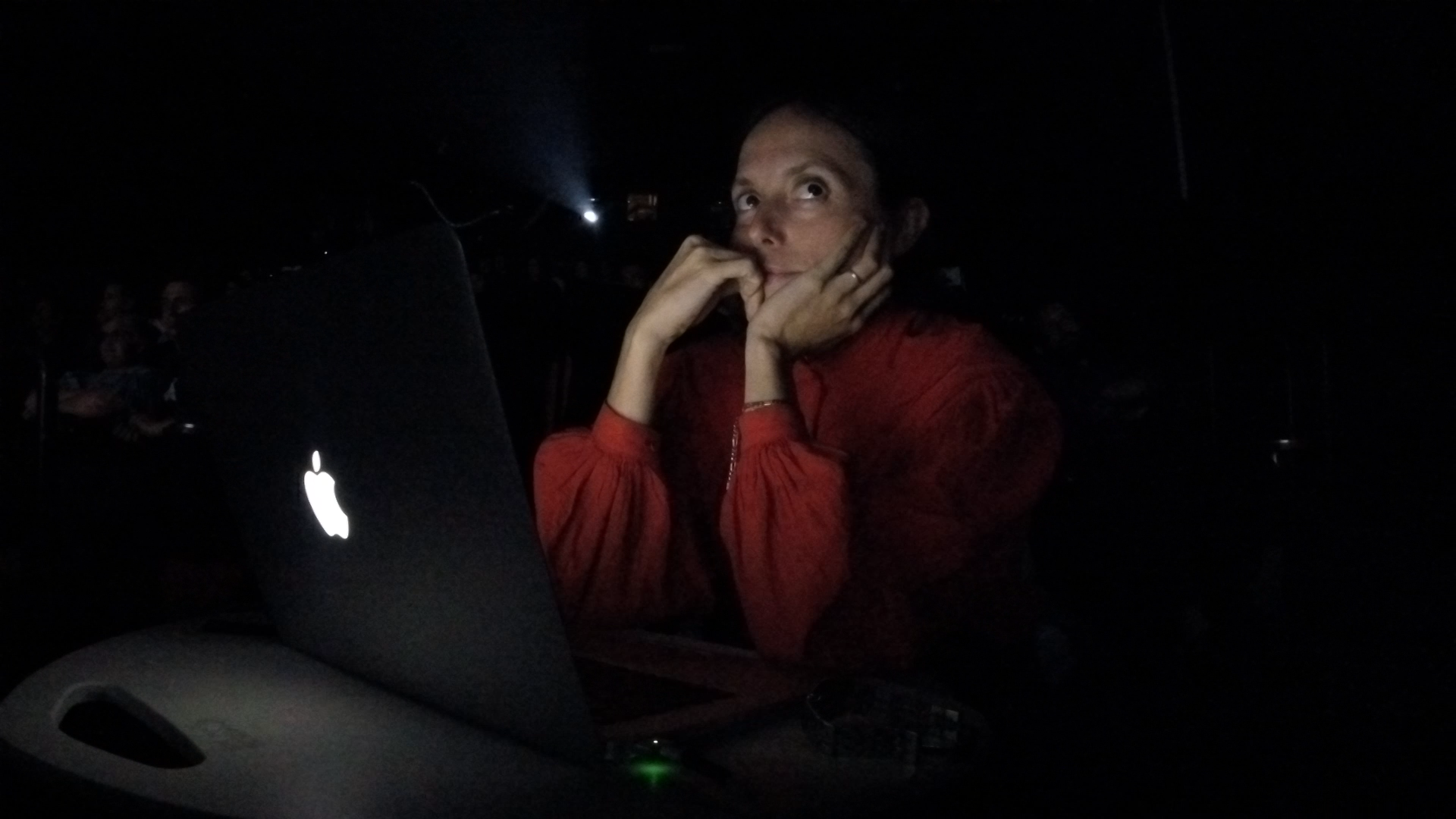zia anger sits behind her laptop during a performance